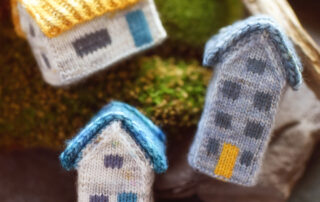 three colorful knitted houses