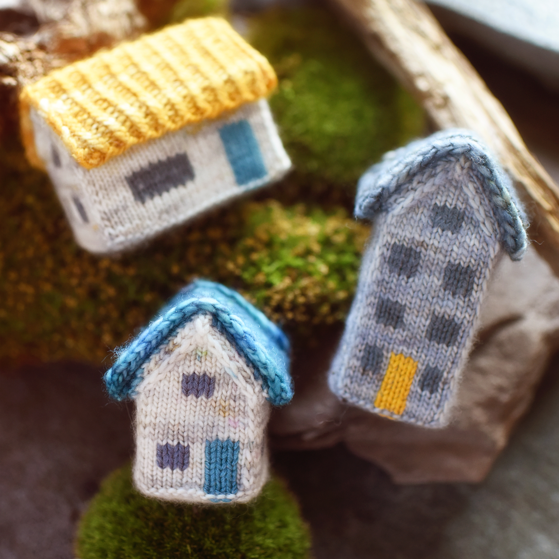 three colorful knitted houses